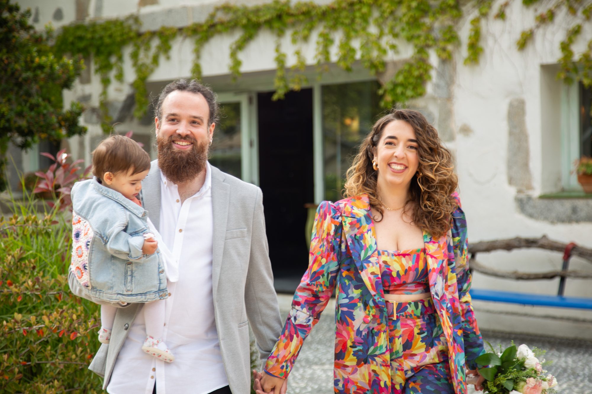 Los novios caminando con su hija en brazos