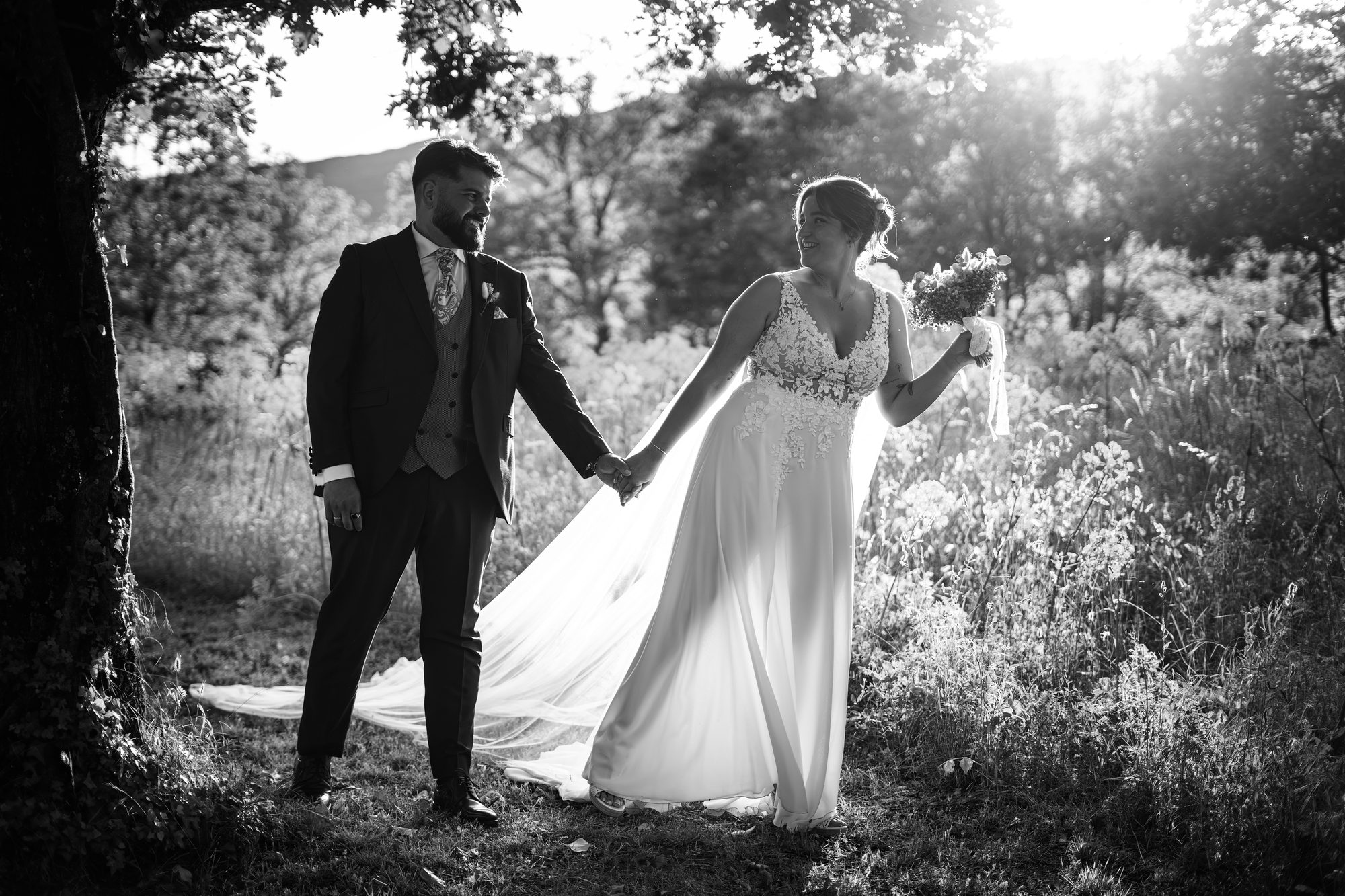Los novios de la mano entre árboles